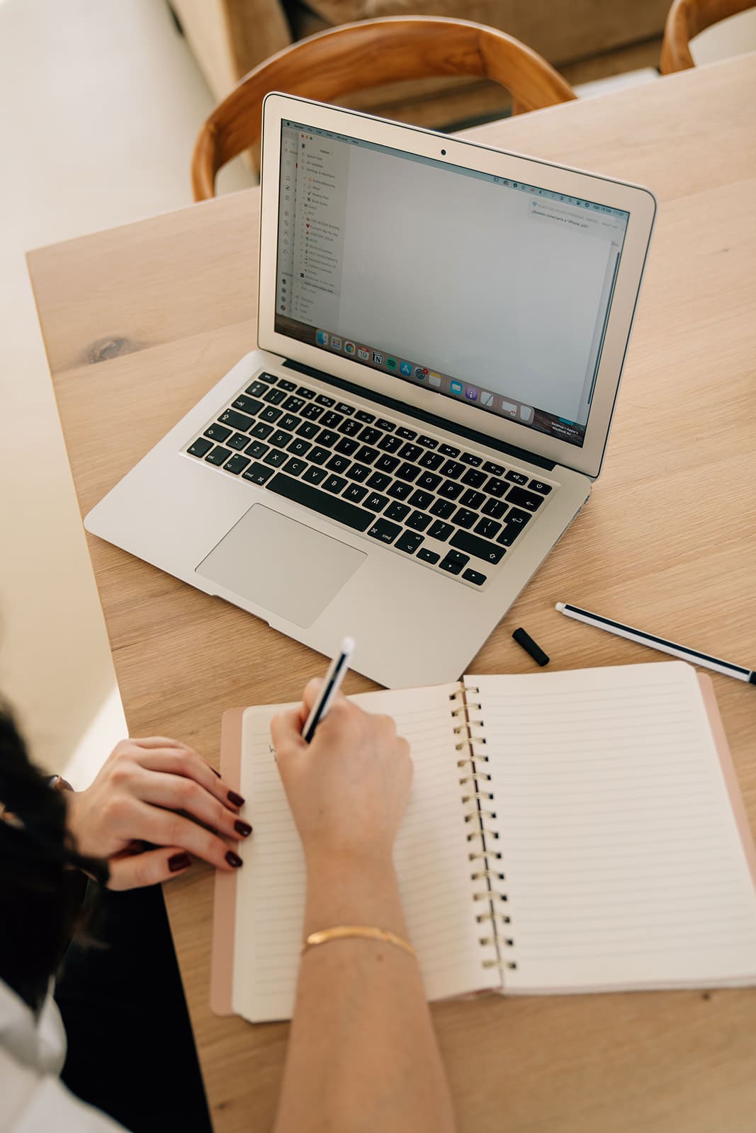 Woman writing in a notebook at her desk after receiving feedback at work