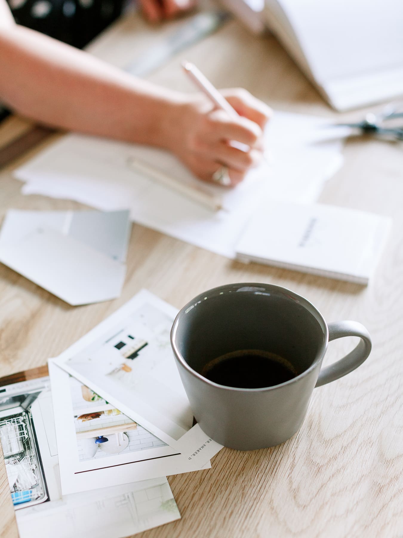 Woman writing notes at her desk preparing to give constructive feedback to a team member